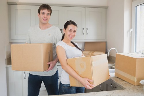 Removalists moving furniture from a Surrey house into a transport vehicle